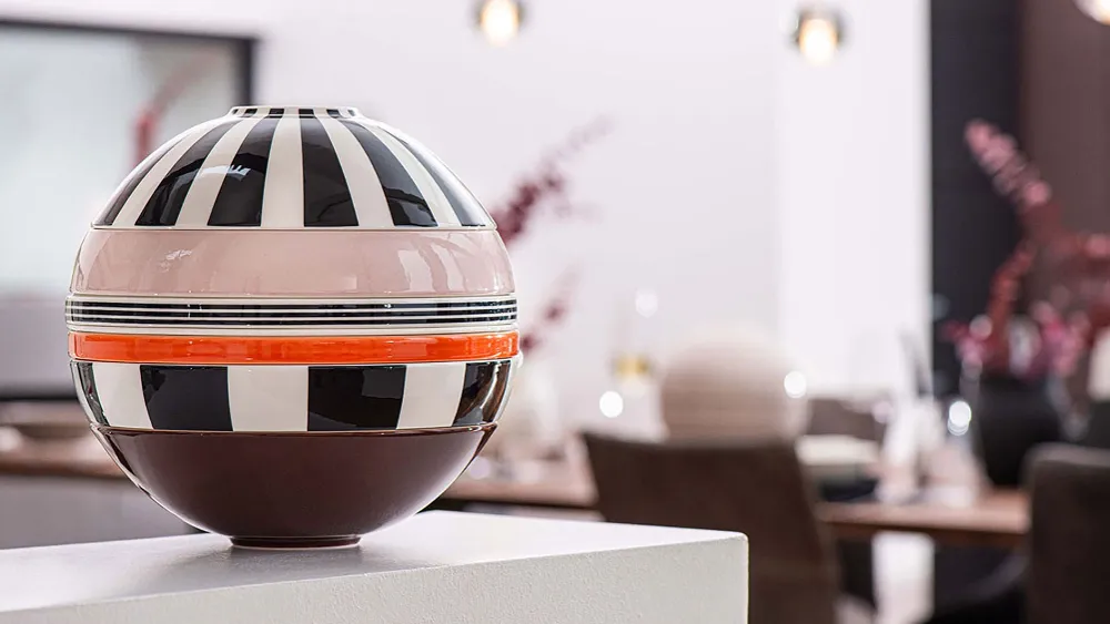 A Villeroy & Boch striped La Boule Memphis on a table in a dining room.