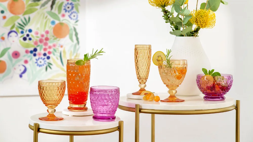 Colorful summer drinks in various Boston glasses on a chic serving table with a flower painting in the background.