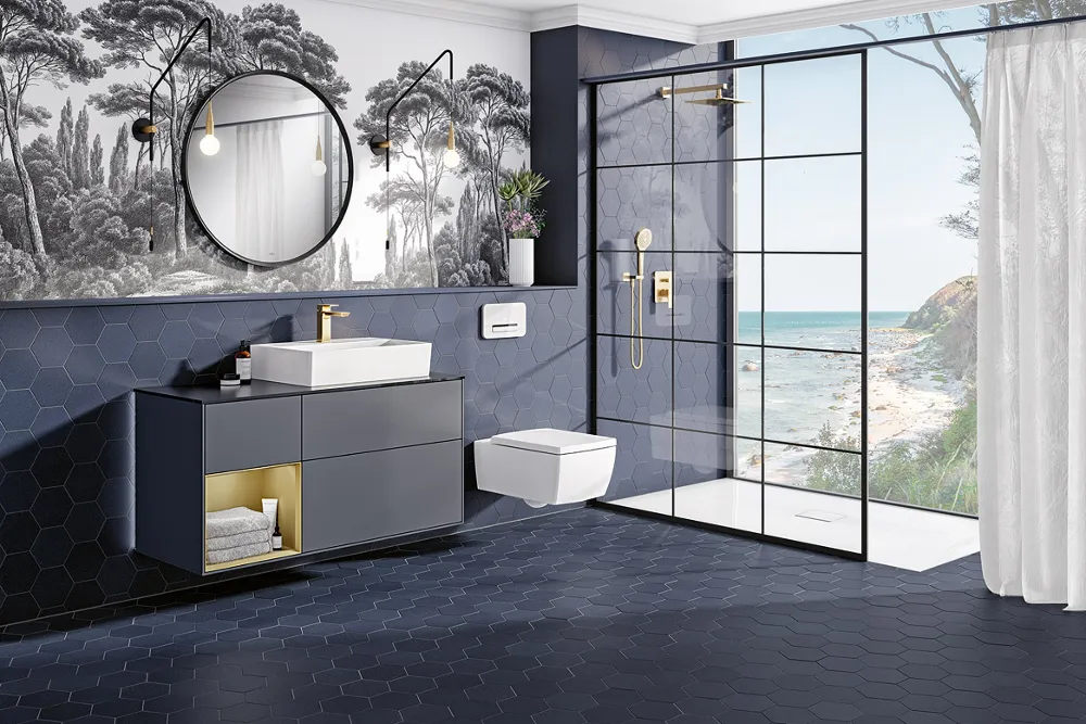 Exclusive bathroom with dark-blue honeycomb tiles and palm wallpaper, white Memento 2.0 toilet, open glass shower and a view of the sea through a large window.