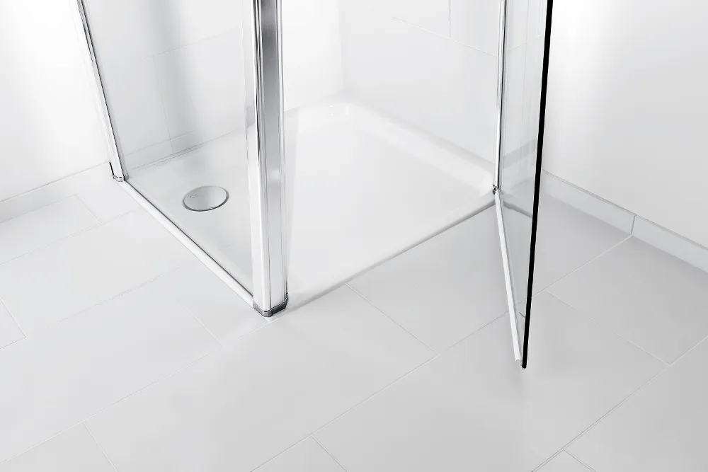 Una cabina de ducha blanca, limpia y moderna de la colección O.novo con puerta de cristal abierta, suelo de baldosas y desagüe.