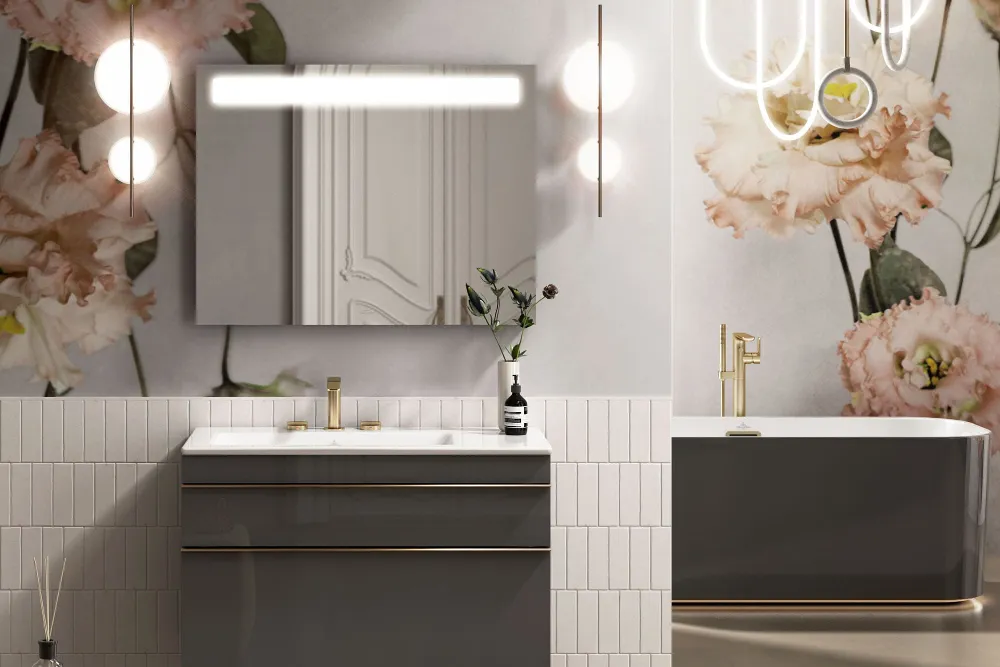 Modernes Badezimmer mit Blumentapete, beleuchtetem Wandspiegel, elegantem Venticello Waschbecken, Badewanne und modernen Lampen. Der Raum ist mit einer Vase und einem kleinen gelben Hocker dekoriert.