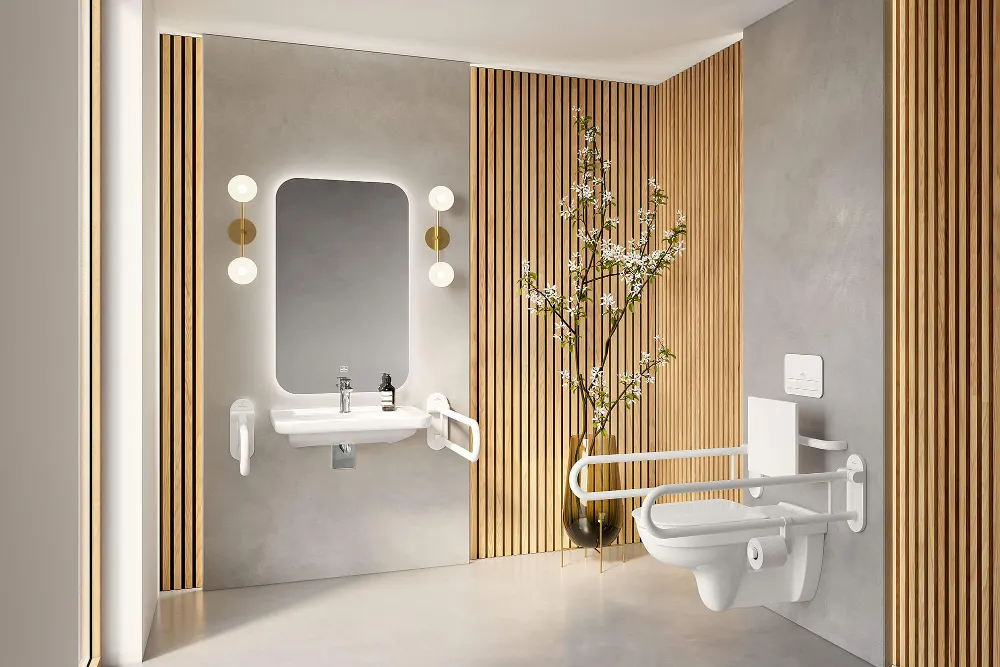 Ein barrierefreies Badezimmer mit Klappgriffen an Waschbecken und WC. In der Raumecke steht eine Pflanze in einer großen Vase.