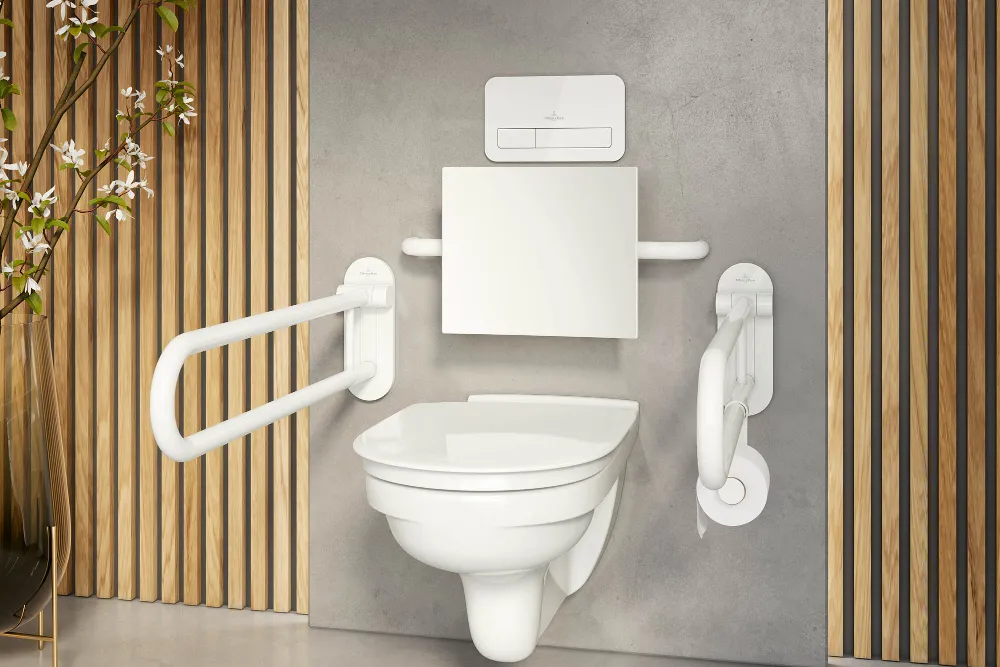 A modern accessible bathroom with a wall-mounted toilet, grab handles on both sides, wooden slats as decoration and a grey wall in the background.