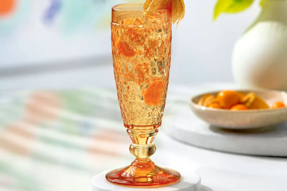 An orange champagne glass from Villeroy & Boch on a table.