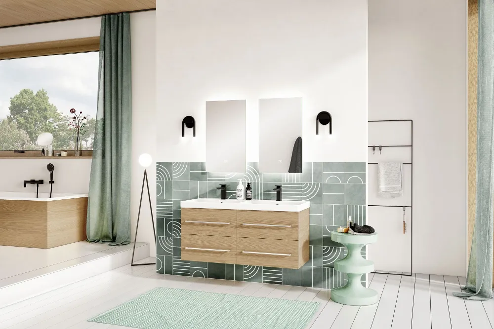 Modernes Badezimmer mit Holzdecke, grün-weißen Fliesenakzenten, einem Doppelwaschtisch der Kollektion Avento und Wandspiegeln. Links eine Badewanne am Fenster, grüne Vorhänge und minimalistische Dekoration.