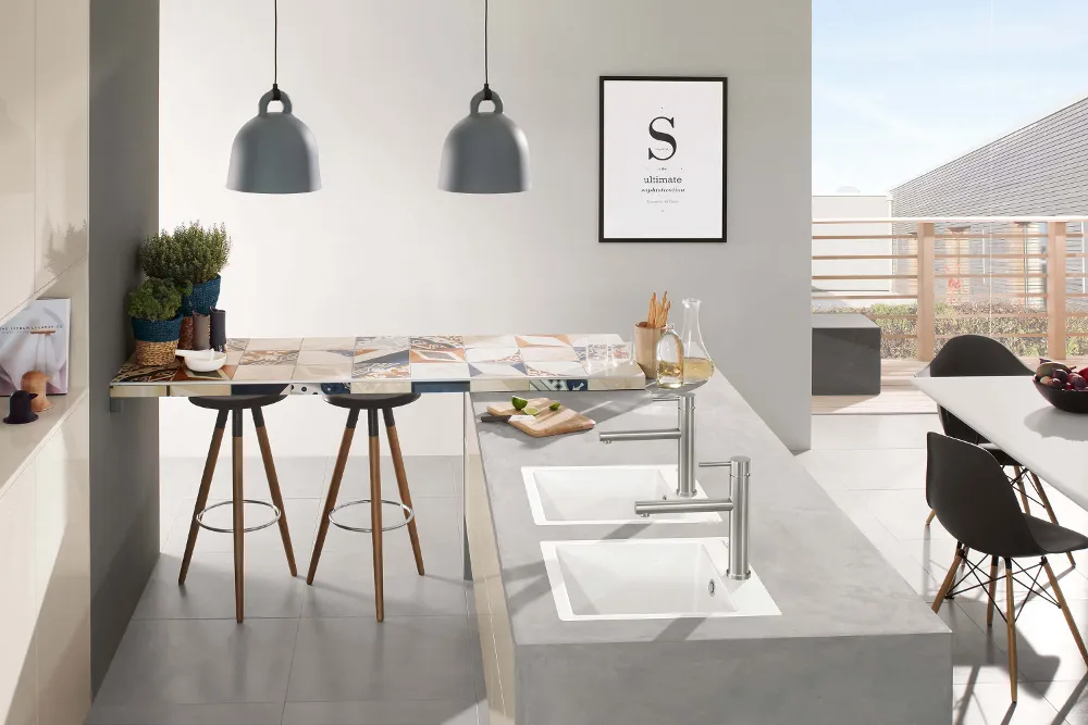 Eine moderne Küche mit zwei weißen Küchenspülen, eingebauten Küchenschränken und Theke mit Hockern.