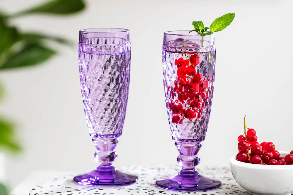 Two purple Boston champagne glasses with berries.