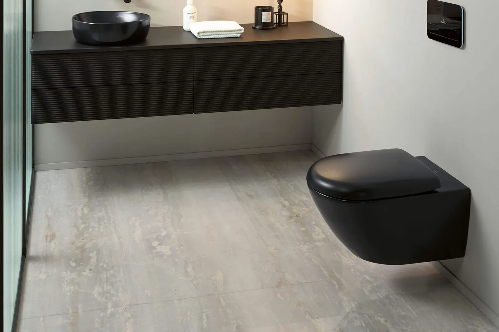 Un bagno con WC e lavabo neri della collezione Antao in un bagno moderno dal look bianco e nero.