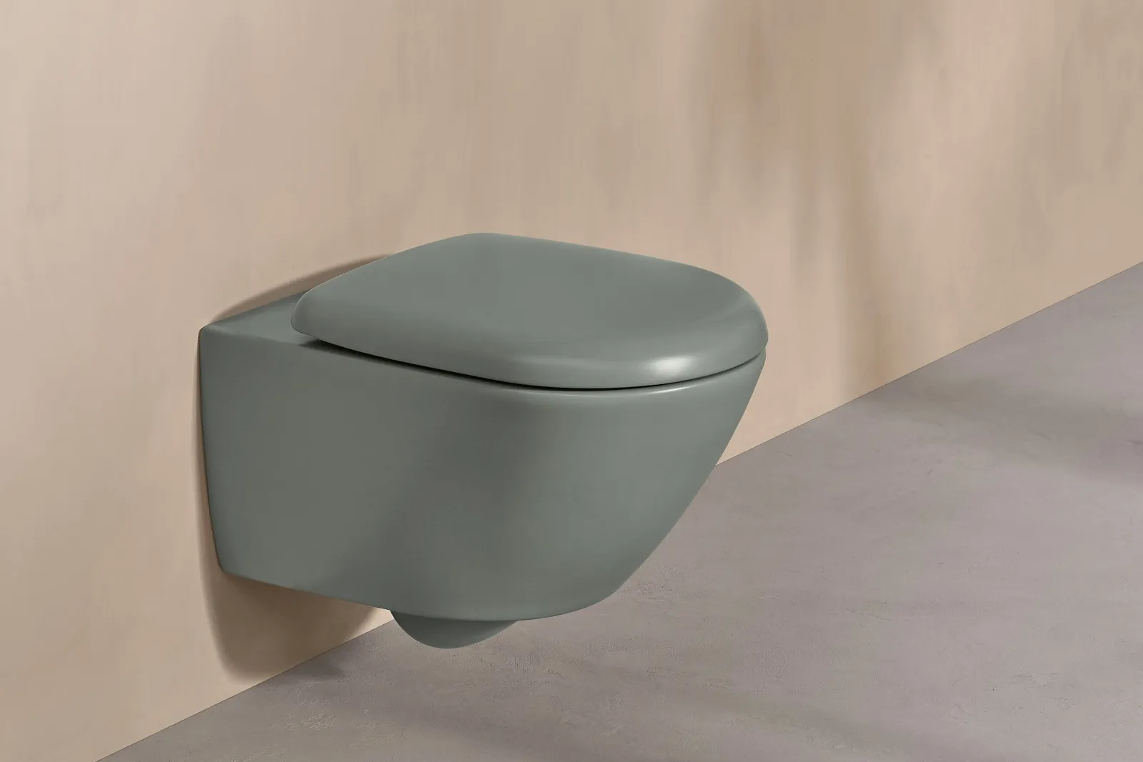 Des WC Villeroy & Boch de la collection Antao verts avec une plaque de déclenchement blanche sur un mur dans un ton naturel.