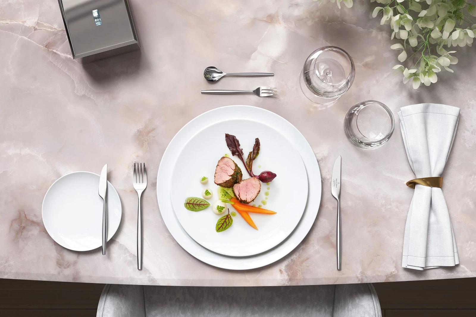 Stylish marble table with gourmet dishes on white MetroChic plates, accompanied by MetroChic flatware and floral decorations.