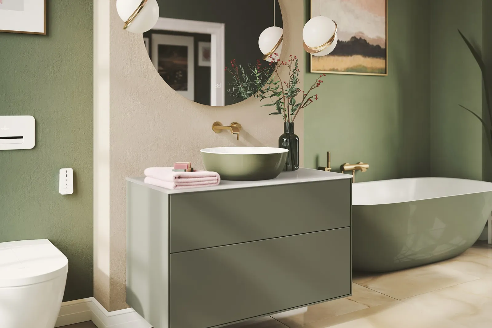 Bagno moderno con lavabo e vasca verdi, specchio rotondo, rubinetto a parete, lavabo bianco, piante ornamentali e due lampade a sospensione. Sullo sfondo si vedono una vasca da bagno e una parete artistica.