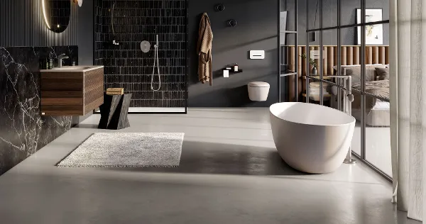 Une salle de bains ouverte de type loft avec de la céramique de salle de bains Antao, un meuble, une baignoire et une douche Une salle de bains moderne avec des murs sombres, une baignoire en îlot, une cabine de douche en verre, un plan de toilette en bois avec un miroir rond et des toilettes. La pièce dispose d’éléments de design élégants et d’une lumière naturelle abondante.