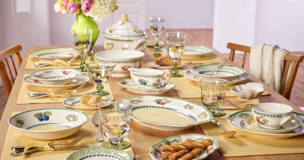A beautifully arranged table featuring plates, cups, and bowls, prepared for dining.  