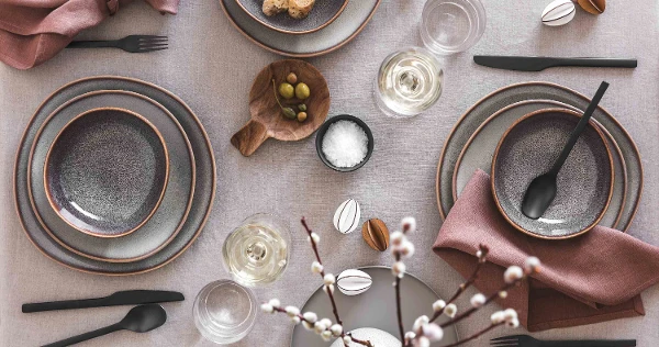 Une décoration de table élégante avec de la vaisselle Lave, des couverts de table Manufacture et des décorations de Pâques simples dans une palette de couleurs neutres.