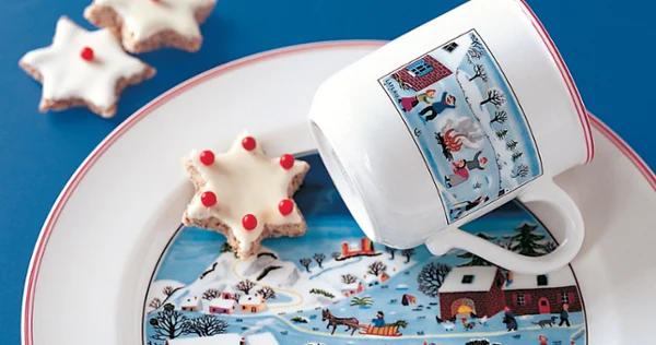 Design Naif Christmas mug on plate Design Naif Christmas mug placed on a plate with a star shaped cookie.