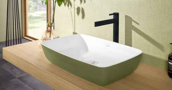 Dawn-servantarmatur med servant Moderne rektangulær servant på en benkeplate i tre på et bad med en grønn fondvegg