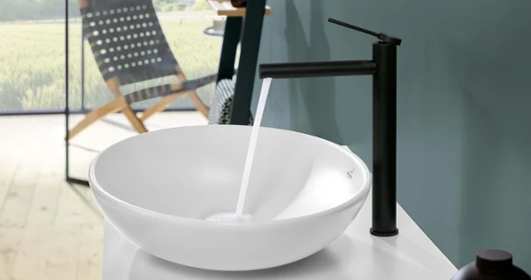 Hvit Loop&Friends servant med armatur En hvit Loop&Friends toppmontert servant på et bad med et landskap i bakgrunnen