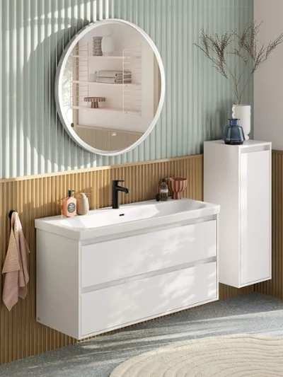 Royale wasplaats in wit met de Villeroy & Boch Skyla collectie. Royale, moderne wasplaats in pastelkleuren bestaande uit wastafelmeubel met witte onderkast, ronde verlichte spiegel, zijkast en zwarte kraan uit de Skyla badkamercollectie.