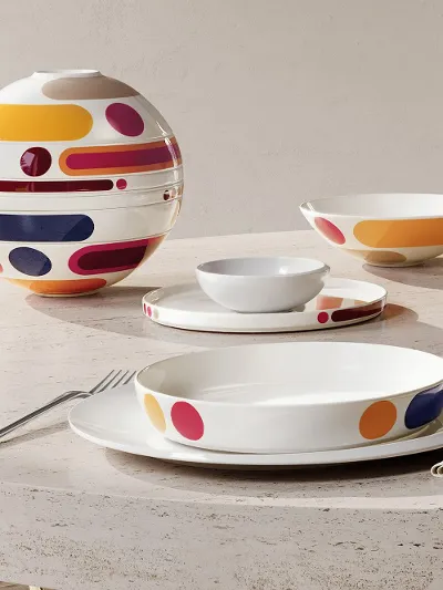 La Boule Miami on an oval stone table Oval stone table with modern, colorful La Boule Miami. Once assembled, once as individual pieces, arranged at a large window with a chair.