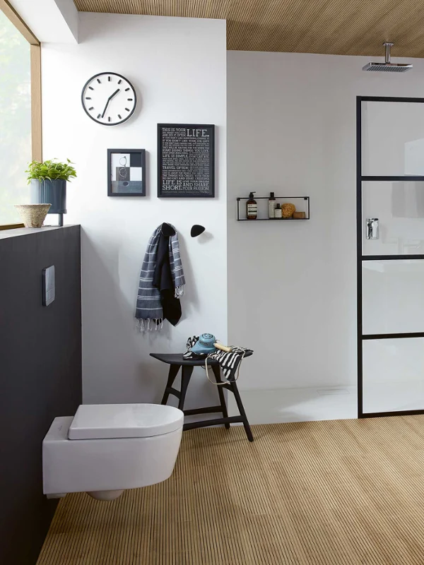 Une salle de bains moderne avec des WC suspendus Avento, un plan double blanc, une douche vitrée et des éléments en bois