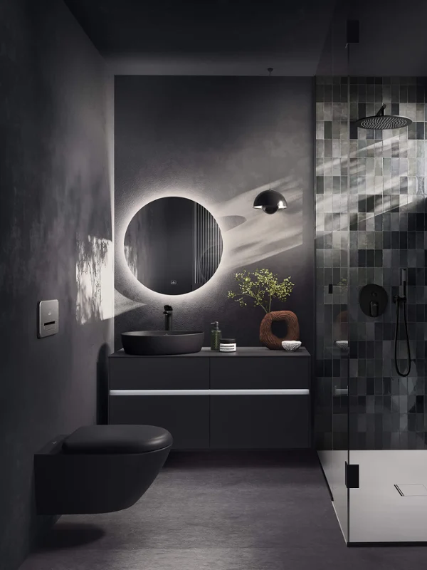 Salle de bain moderne avec des carreaux foncés, un miroir rond, un lavabo flottant et une douche vitrée avec lumière naturelle.