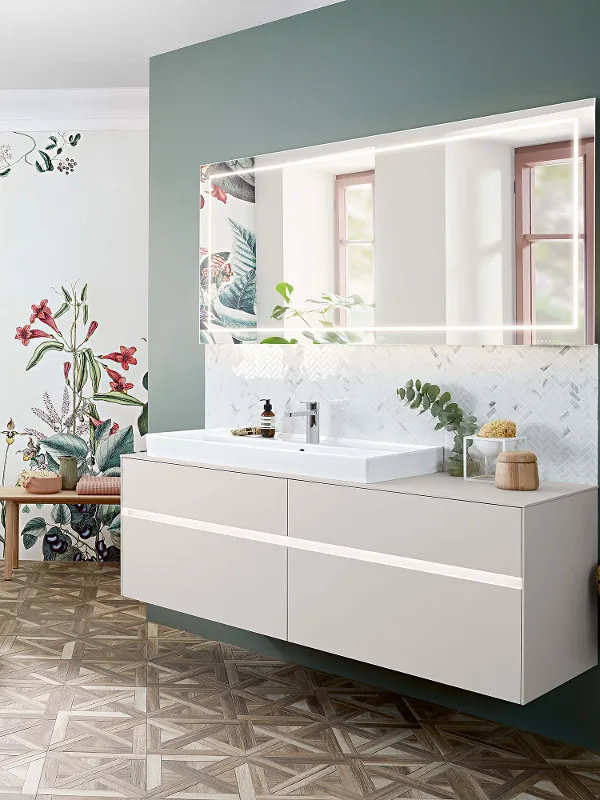 Ein Collaro Waschbecken, Möbel und Badewanne in einem Badezimmer mit einer Blumentapete.