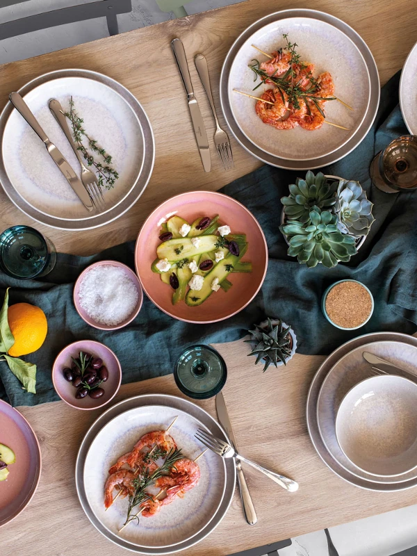 A table is set with Perlemor dinnerware and Mediterranean food.