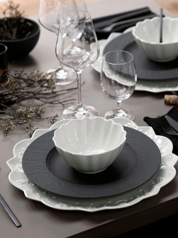 A table set with black Manufacture plates and white Toy’s Delight dinnerware from Villeroy & Boch.