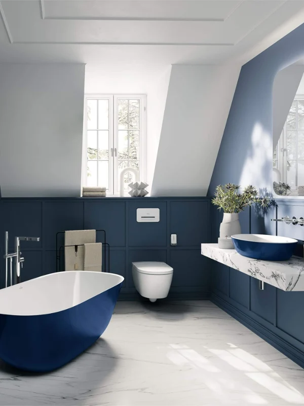 Vintage-style bathroom with a sloping ceiling containing a Villeroy & Boch Artis 
washbasin and a Theano bath in blue.