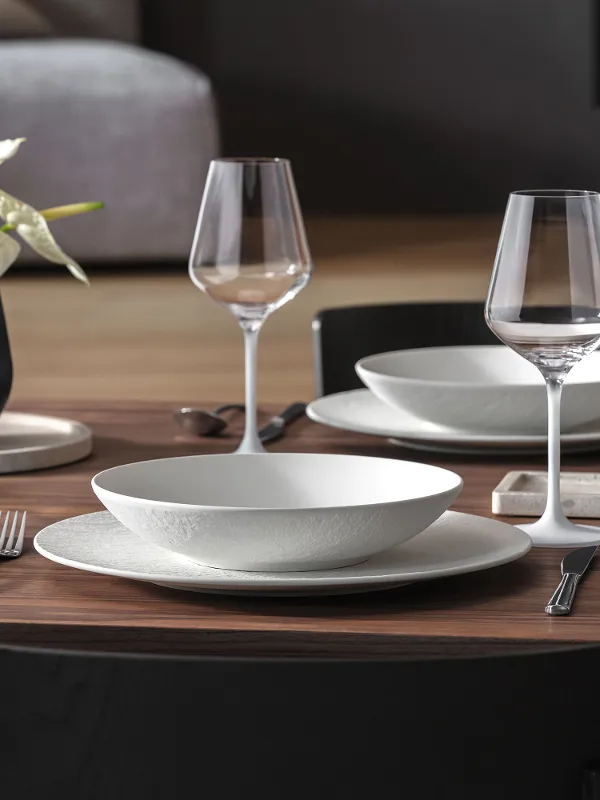 Manufacture Rock, Collier Vase, Travertine & Noir Table Set with Lantern and Candle Holder Ein sorgfältig arrangiertes Set mit Manufacture Rock, Collier Vase, Travertine, Noir Laterne und Kerzenhalter in einer eleganten modernen Tischdekoration.