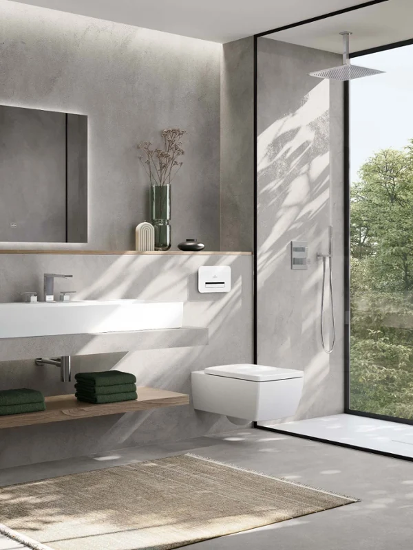 Bagno minimalista con Memento 2.0 di Villeroy & Boch. Lavabo e wc sospeso. Il design combina linee pulite, pareti grigie sottili e una doccia walk-in con vista sul verde.