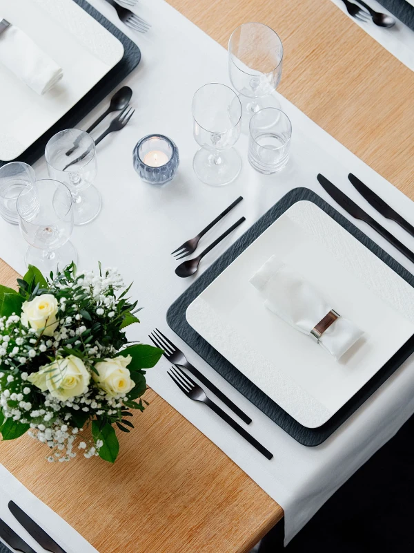 A set table with square Manufacture plates in black and white with NewMoon glasses.