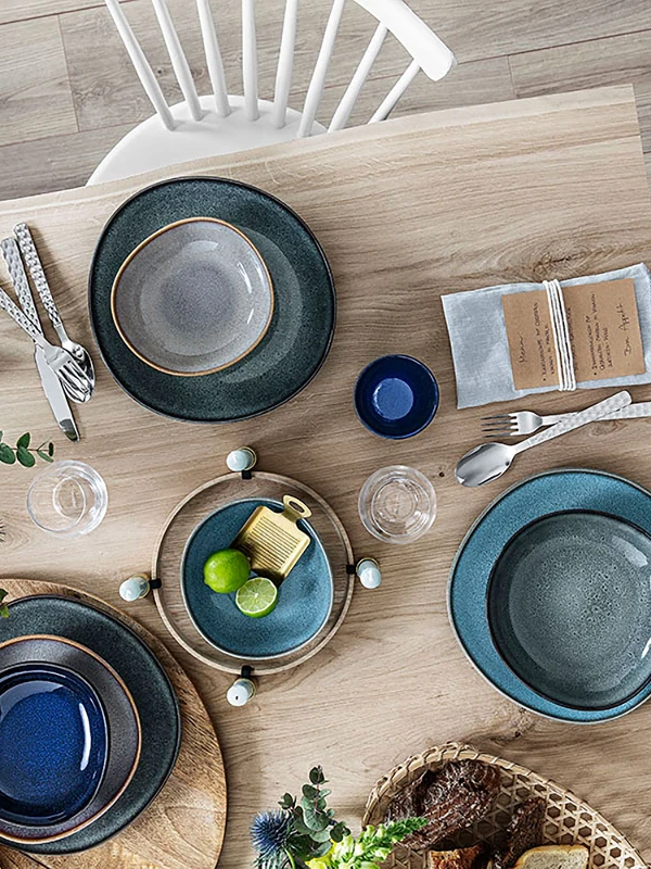 Une table en bois avec des assiettes Lave de Villeroy & Boch posées dessus.