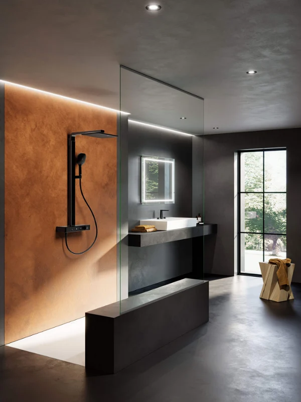 Infinity Showers dusjsystem med dusjkar Moderne bad i minimalistisk design med innglasset dusj, veggmontert svart dusjhode, stort speil med belysning, servant med mørk benkeplate og en krakk ved siden av et vindu.