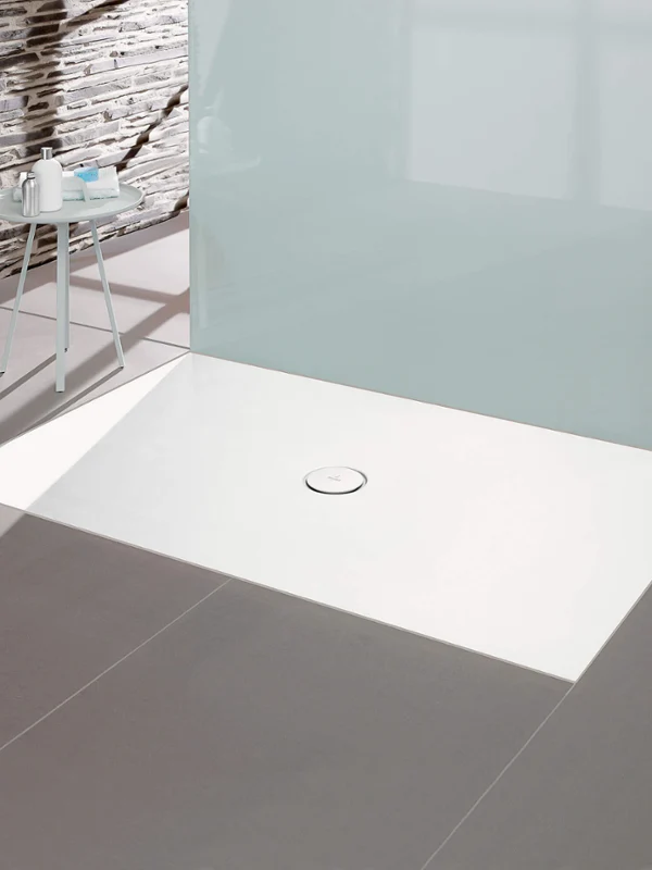 Minimalist bathroom with a white rectangular shower tray, glass screen and grey tiled floor.