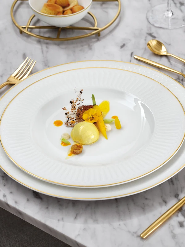 Elegantes Tischgedeck mit Villeroy & Boch Geschirr aus der Kollektion Château Septfontaines, goldenen Besteck und Gläsern.