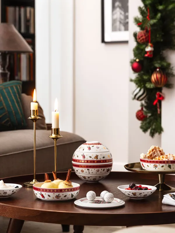 Festive living room ambience with decorated Christmas tree, burning fireplace, and a table set with the Toy’s Delight La petite Boule.