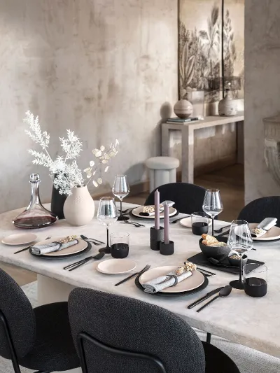 A large natural stone table set with Manufacture Rock crockery, glasses and cutlery and a Manufacture Collier vase.