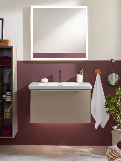 Une salle de bains avec un lavabo Subway 3.0, un miroir, une armoire et un mur rouge.