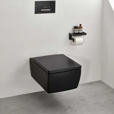 Interno bagno minimalista con WC sospeso in nero opaco e decorazioni a mensola sotto il soffitto mansardato