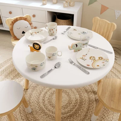 Une table dressée dans une chambre d’enfant avec de la vaisselle Boho-Kids, des couverts de table et des verres sur le thème des animaux dans des couleurs pastel.