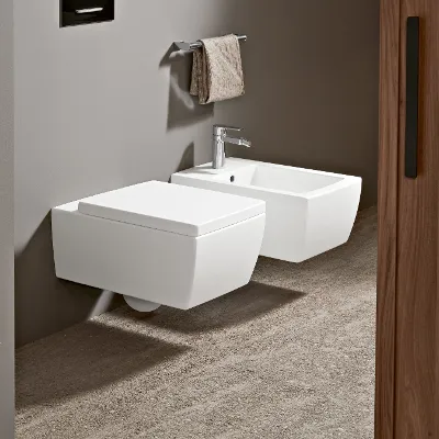 Moderne weiße Memento 2.0 Toilette und Bidet im minimalistischen Design in naturfarbenem Bad