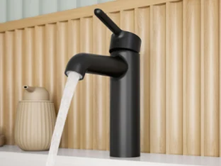 Mattschwarze Waschbecken-Armatur in einem soften, runden Design aus der Skyla Badkollektion, gezeigt mit vollem Wasserstrahl.
