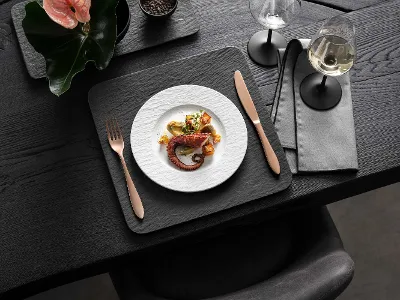 Elegant dining room with gourmet food, wine and modern Manufacture crockery Elegant dining room with gourmet food, wine and modern Manufacture crockery in black and white on a dark wooden table.