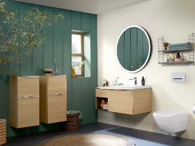 Bagno Subway 3.0 con parete verde Mobili da bagno Subway 3.0 con lavabo e WC in un bagno accogliente con parete verde e finestra.