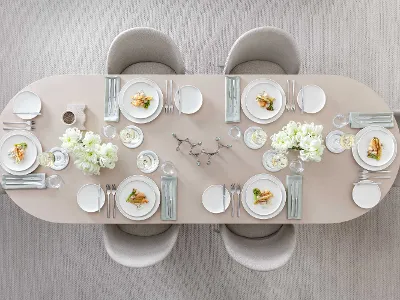 Stoviglie Afina con posate Piemont e cibi deliziosi su un tavolo da pranzo beige Elegante tavolo da pranzo apparecchiato per sei persone, con stoviglie bianche Afina, posate Piemont e cibi deliziosi.