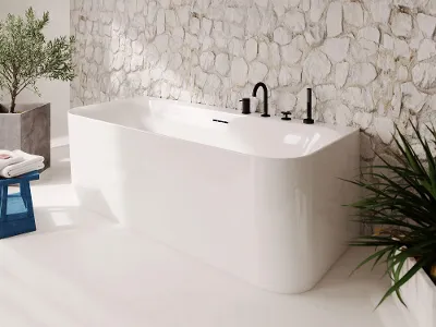 Vasca da bagno Loop & Friends bianca di fronte a un muro di pietra Bagno moderno con vasca free-standing bianca Loop & Friends su una parete di pietra testurizzata dove la luce del sole proietta ombre morbide
