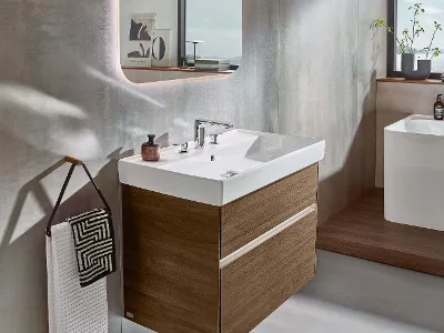 Mobile lavabo Collaro in un bagno moderno con vista mare Bagno moderno con pareti strutturate, lavabo bianco Collaro, grande specchio e vista sul mare attraverso la finestra.