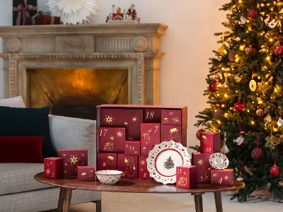 Christmas Toys Memory - ideale da regalare Un soggiorno festivo con un albero di Natale decorato, un calendario dell'Avvento Villeroy & Boch e piatti a tema natalizio su un tavolo di legno.