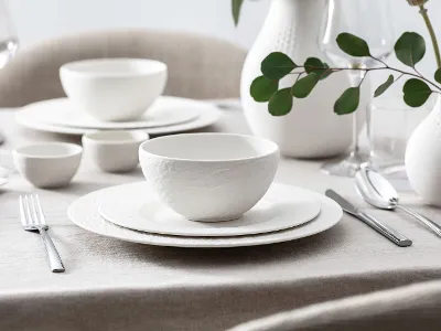Manufacture dinnerware with simple decoration Elegant, white dinnerware set from the Manufacture collection on a table with simple decoration.